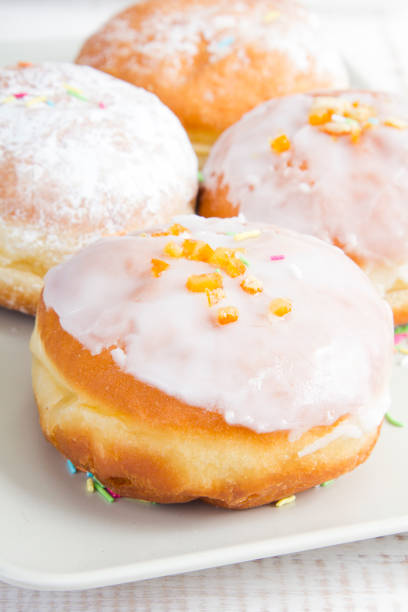 donuts with frosting and powdered sugar on a platter
