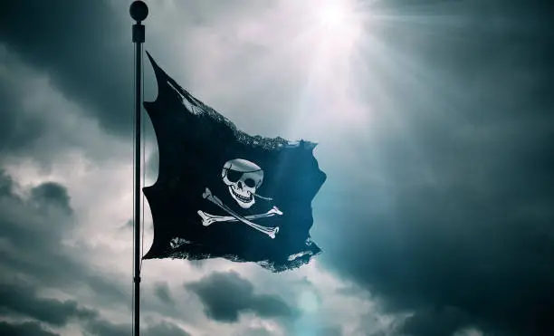 ripped tear grunge old fabric texture of the pirate skull flag waving in wind, calico jack pirate symbol at cloudy sky with sun rays light, dark mystery style, hacker and robber concept