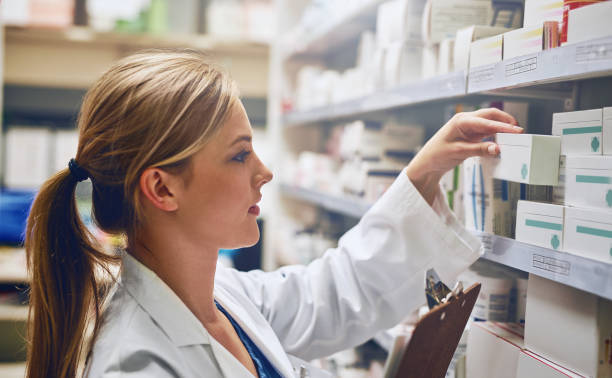 Pharmacists improve medication adherence Shot of a pharmacist looking at medication on a shelf healthcare and medicine business hospital variation stock pictures, royalty-free photos & images