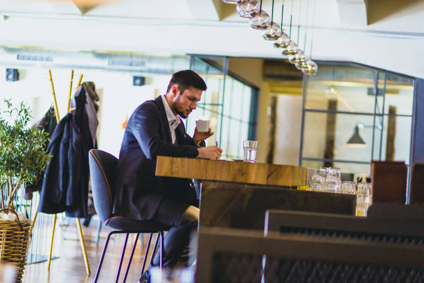 istock Handsome, young  businessman, sitting in a bar, drinking coffee, handwriting 660143676