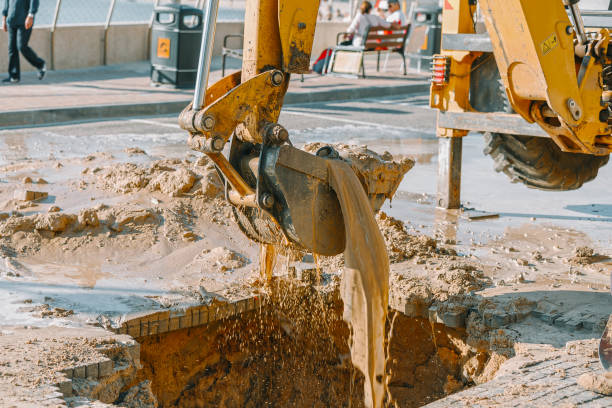 istock Excavator cleaning mud from area with broken pipeline 660149714