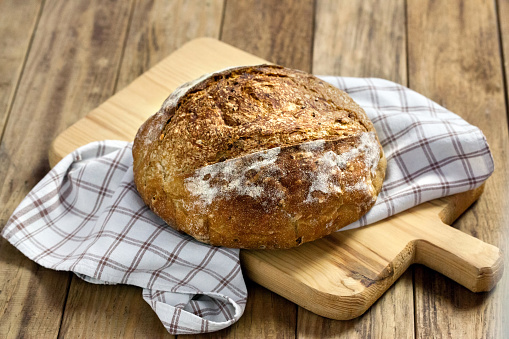 Load of bread with napkin on wooden cutting board