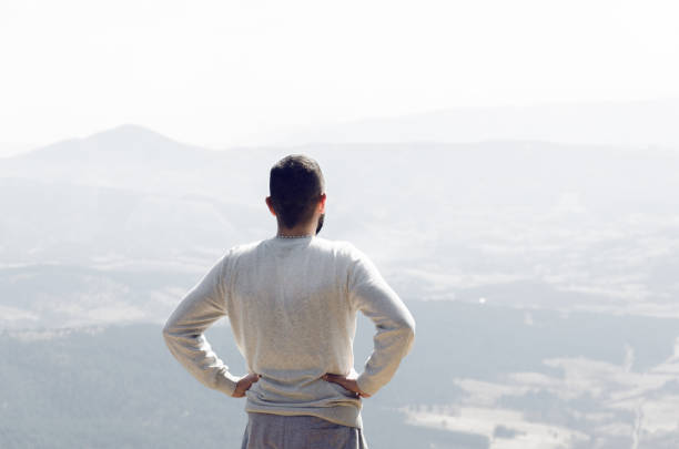 istock man with his back turned looking at mountain landscape 660153090