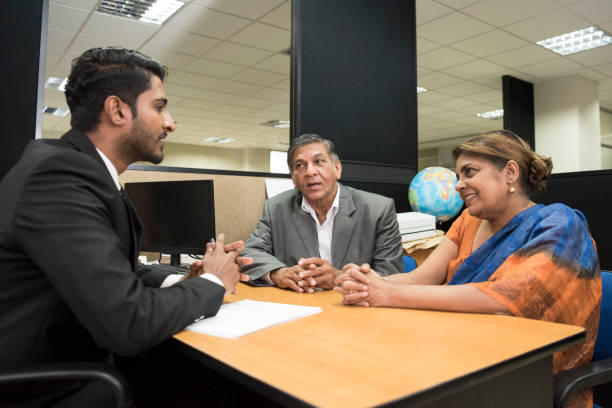 Financial advisor in meeting with senior couple Mature woman and senior man sitting at desk facing young businessman giving financial advice interview event stock pictures, royalty-free photos & images