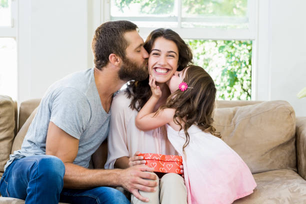 Mother receiving a gift from her husband and daughter