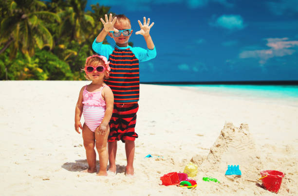 istock little boy and girl having fun on beach 660211204