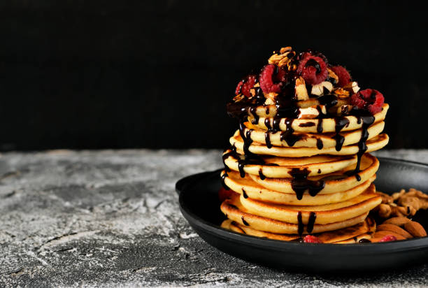 istock Homemade Pancake with raspberries, nuts and chocolate on a stone background 660220622