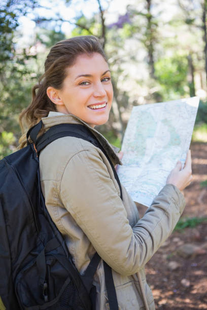 istock Smiling woman holding the map 660220696