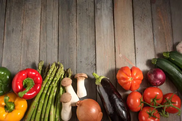 Fresh asparagus and other vegetables on rustic wooden table for a healthy nutritional concept