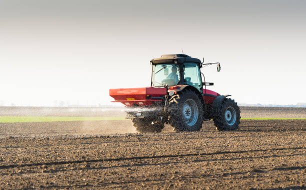 istock Tractor spreading artificial fertilizers  in field 660223130
