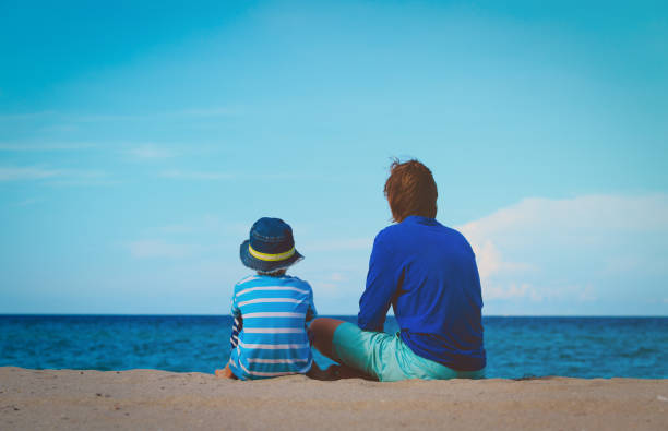 istock father and little son talking on beach 660224608