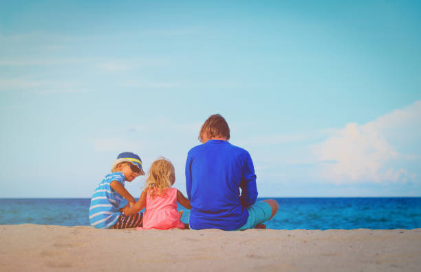 istock father with little son and daughter on beach 660224810