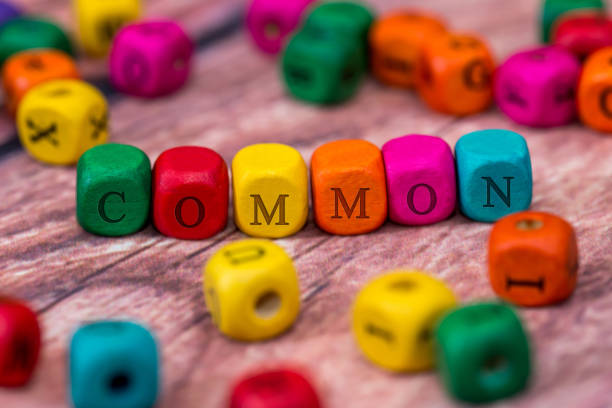 istock common - word created with colored wooden cubes on desk. 660230418