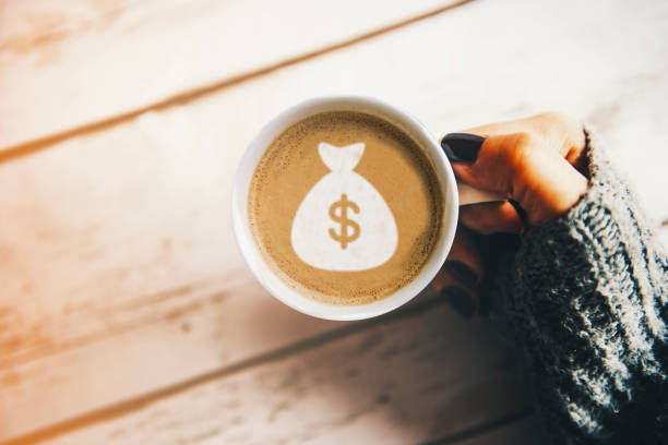 девушка с чашкой кофе с символом сумки с деньгами - food currency breakfast business стоковые фото и изображения