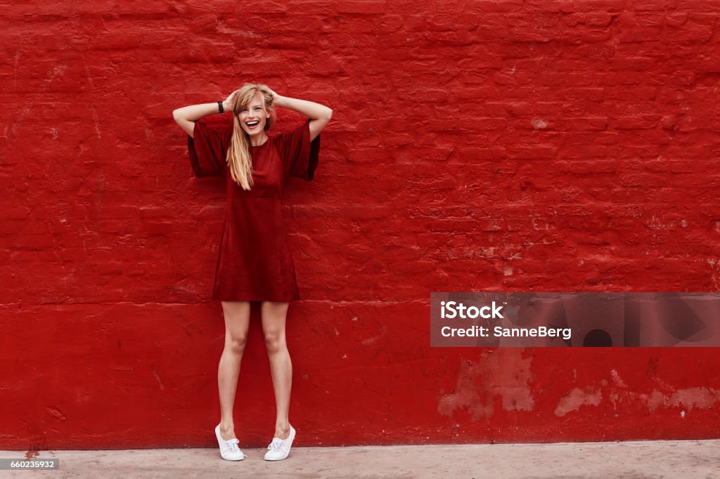 Woman in red Woman in red dress against red wall, portrait Red Stock Photo