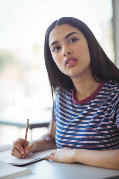 istock Schoolgirl doing his homework in classroom 660237376
