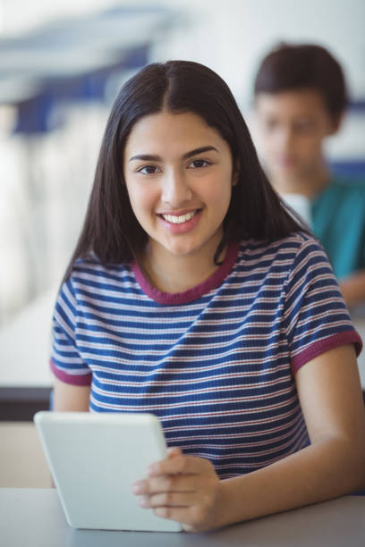 istock Portrait of schoolgirl using digital tablet in classroom 660239316