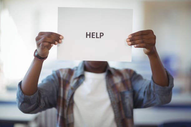 istock Schoolboy holding white paper with text sign in classroom 660248760