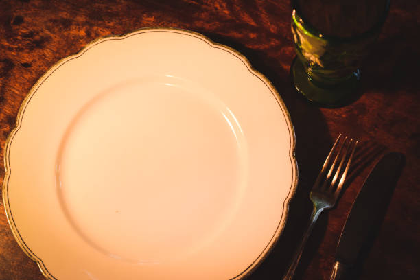 istock White plate, forke, knife, antique wooden table 660250242