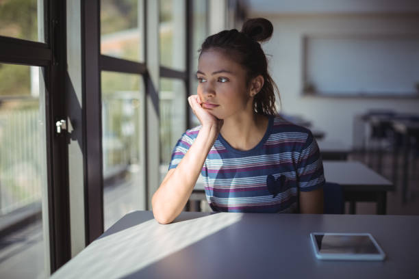 istock Thoughtful schoolgirl sitting in classroom 660254334