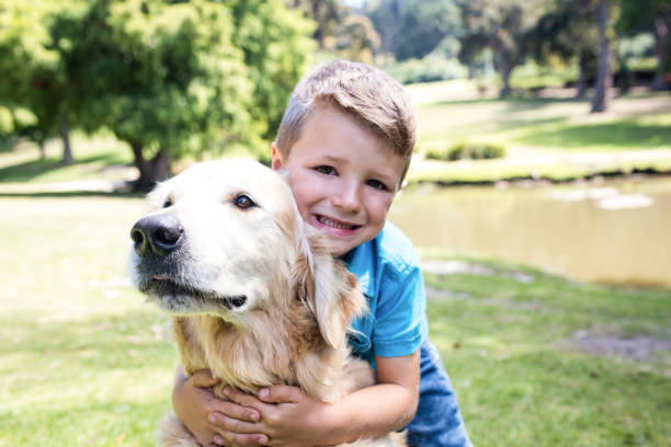 istock Smiling boy with his pet dog in the park 660255208