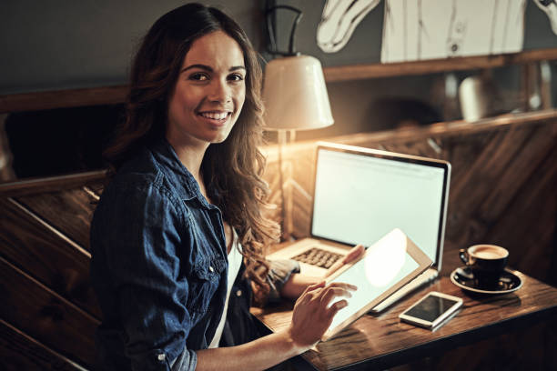 Who needs an office anyway? Portrait of a relaxed young woman using wireless technology in a coffee shop anyway stock pictures, royalty-free photos & images