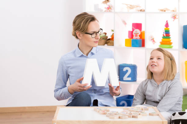 istock Speech therapist helping little girl 660262348