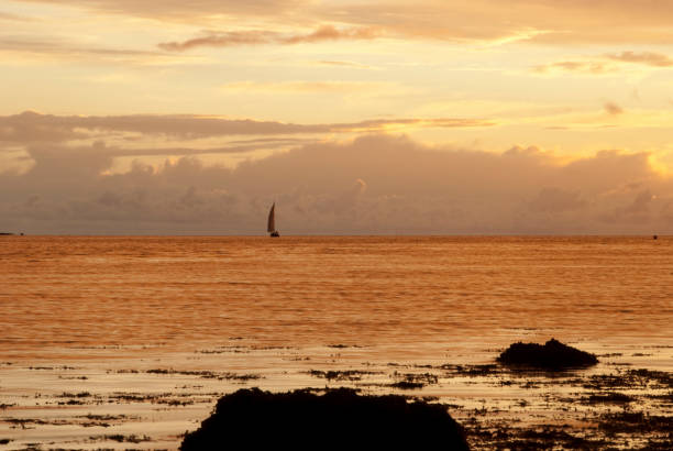 Sailing boat sails the atlantic ocean at dusk. stock photo