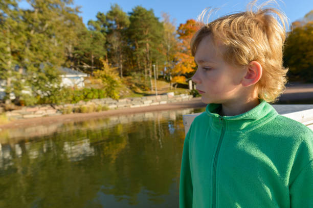 Little boy enjoying a carefree summer day by the river.