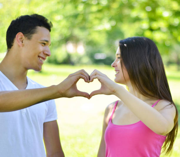 istock Couple making heart with hands outdoor 660298396