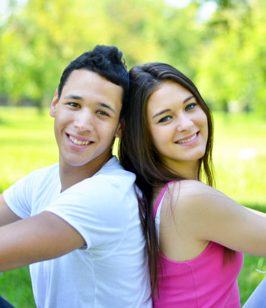 istock Happy young couple back to back in park 660298406