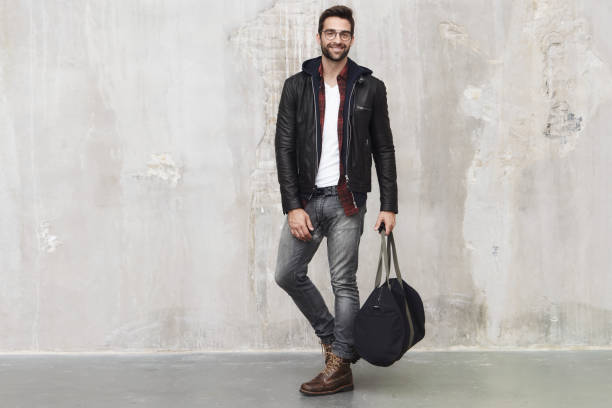 ragazzo sorridente con borsa - leather pants foto e immagini stock