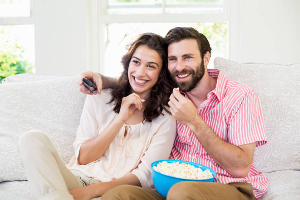istock Couple sitting on sofa watching television 660315642