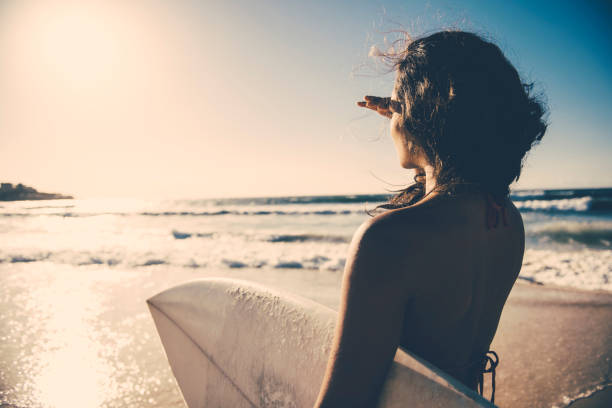 surf girl che guarda in lontananza - surfing new south wales beach australia foto e immagini stock