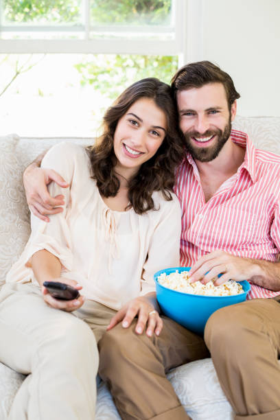 istock Couple sitting on sofa watching television 660315920