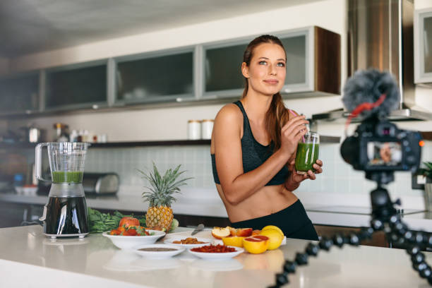 istock Young woman recording content for her video blog in kitchen. 660318304