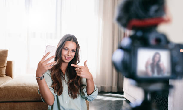 istock Young woman recording her video on camera mounted on tripod. 660318422