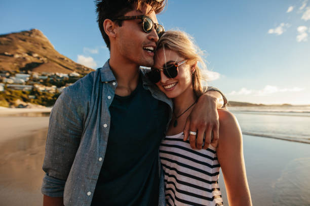 istock loving young couple walking on beach 660319234