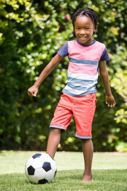 istock Smiling boy kicking the ball 660321716