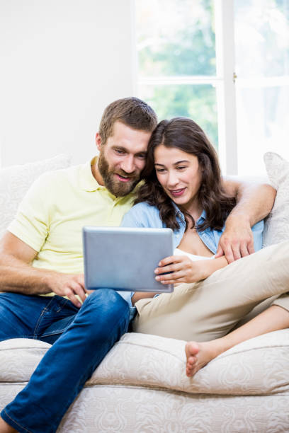 istock Couple using digital tablet in living room 660322396