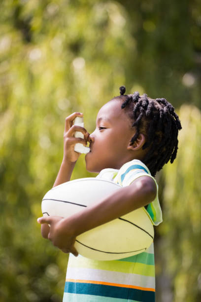 istock Profile view of a kid using an asthma inhaler 660325858