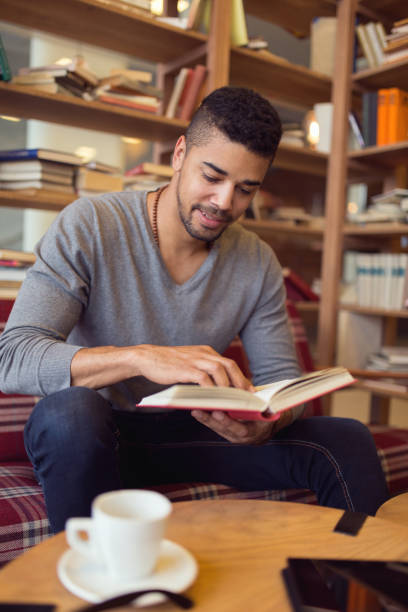istock Smiling African American student enjoying book reading in library 660326038