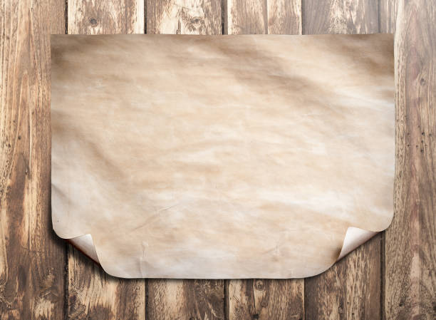 istock Old paper on a brown wooden surface. 660331990