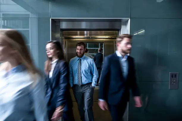 Business people walk out of the lift in the lobby. All rush in conference room on the meeting.
