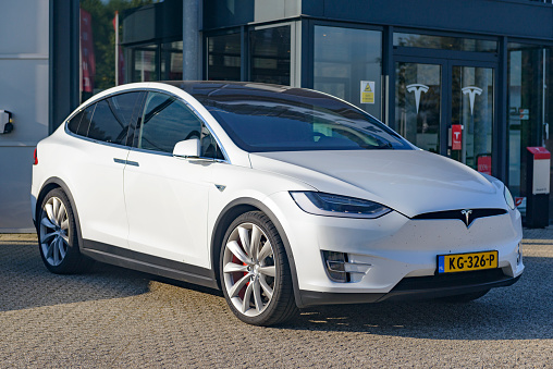 White Tesla Model X P90D all-electric crossover SUV at a Tesla dealership in the town of Duiven in The Netherlands. The Tesla Model X is a full-sized all-electric crossover SUV made by Tesla Motors that uses falcon wing doors.