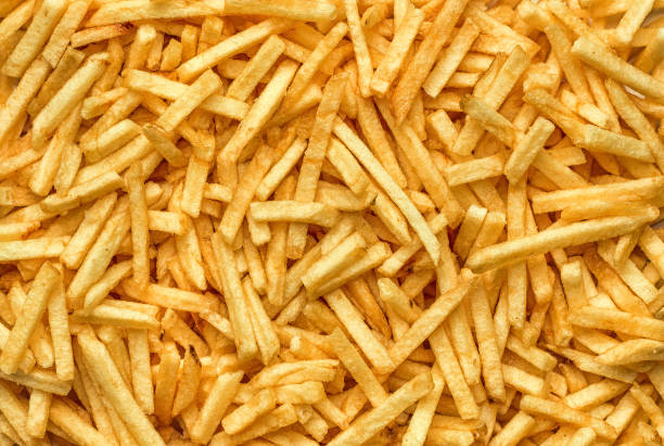Fried fatty potato chips Background of potato chips close-up. The texture of the corrugated chips. french fries stock pictures, royalty-free photos & images