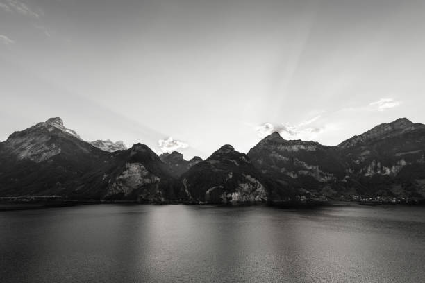 Grandiose mountain landscape. Mountain tops in the snow, romantic lake. Black and white