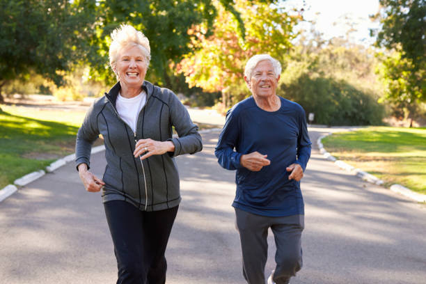 istock Senior Couple Jogging Through Park 660353196