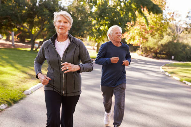istock Senior Couple Jogging Through Park 660353212