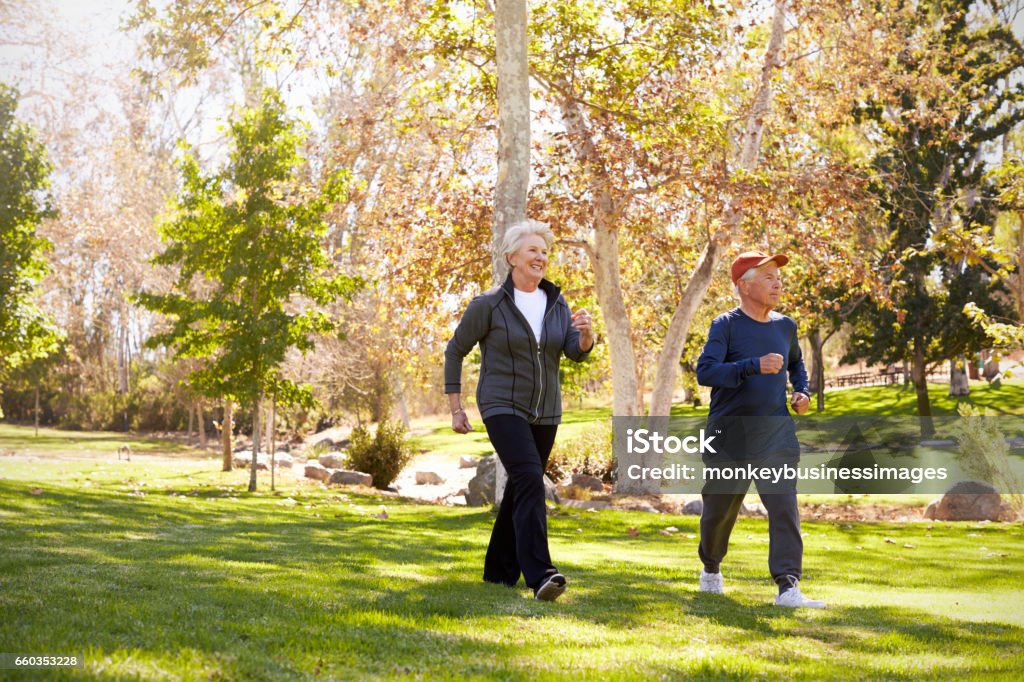 Vue latérale de la puissance de Couple de personnes âgées marchant dans le parc - Photo de Marche sportive libre de droits